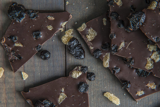 Group of blueberry, cranberry, and ginger dark chocolate bark on gray wood table background