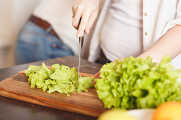women housewifes preparing lettuce and bread on cutting board in kitchen, close up photo soft focus