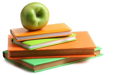 books with bright covers and pads near Apple on a white isolated background to have