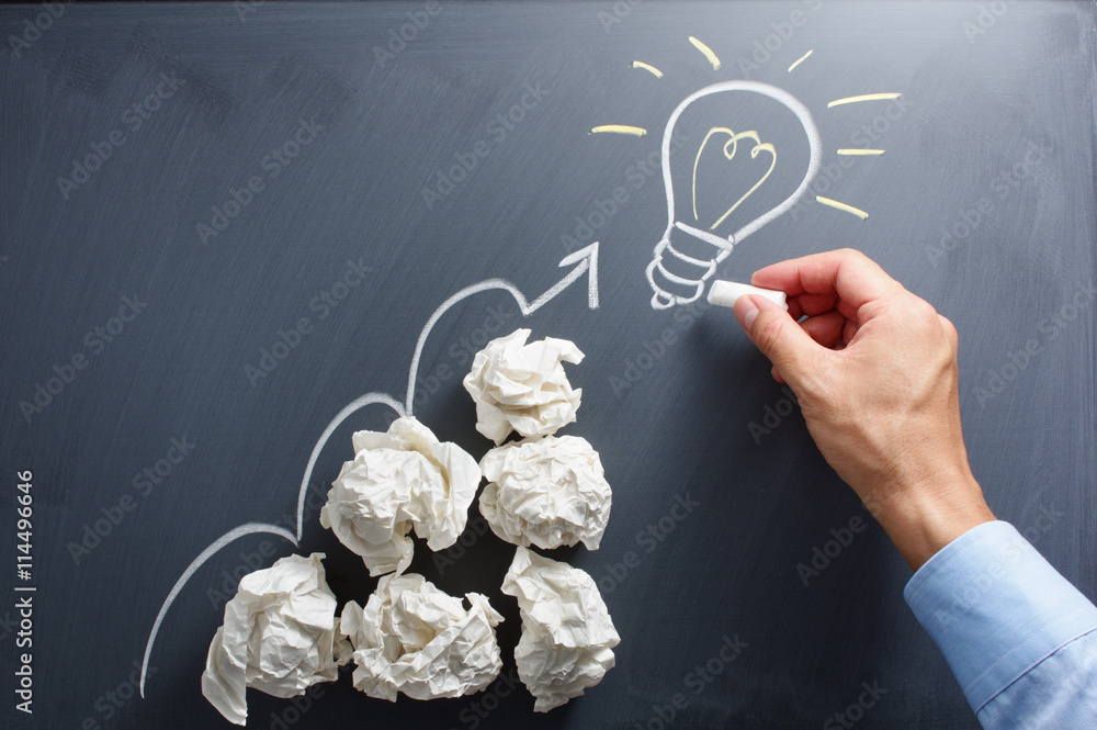 Aufkleber Drawing light bulb on blackboard. Many paper balls. Concept image of developing new idea.
