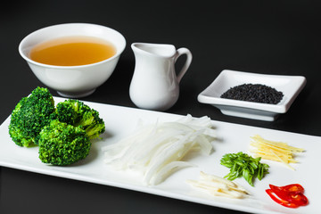 ingredients for a soup on the white plate on the black background