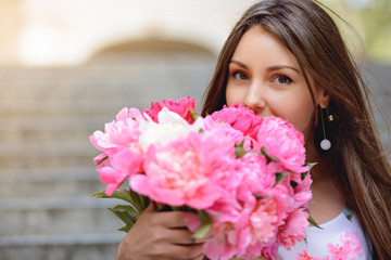 Fototapeta premium Woman with flowers peonies outdoors