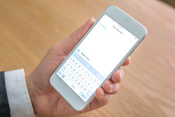 businessman holds mobile phone in office