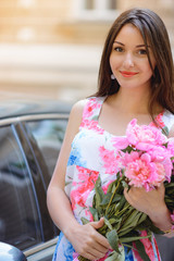 Woman in dress with flowers peonies outdoors
