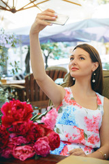 Fototapeta premium Woman with flowers peonies outdoors
