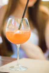 Cocktail in cafe focus, woman on background
