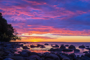 Obraz na płótnie Canvas Vivid sunset over stony coast of Baltic sea