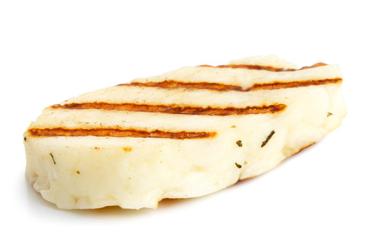 Single grilled slice of halloumi cheese isolated on white in perspective. With grill marks.