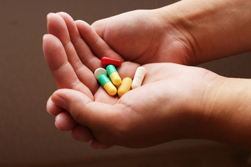 young woman holding pills in hand