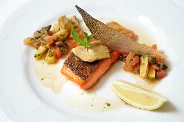 Grilled piece of salmon with vegetable and lemon isolated on white