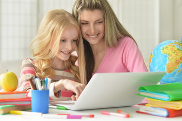 mother helping her  daughter with homework