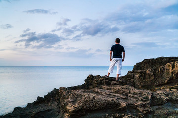 Fototapeta na wymiar Young man standing on a rock