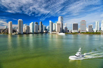 Obraz na płótnie Canvas Aerial view of Miami skyscrapers with blue cloudy sky, boat sail