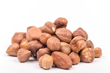 Pile of hazelnuts with copy space over white background