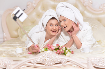Obraz na płótnie Canvas women in bathrobes doing selfie