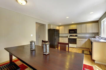 Bright kitchen room with beige cabinets and black appliances.