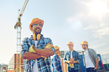 group of smiling builders in hardhats outdoors