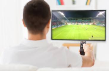 man watching football or soccer game on tv at home