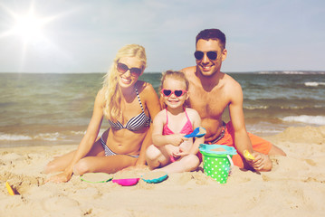 happy family playing with sand toys on beach