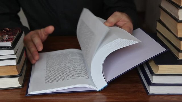 book, close-up of a great book, a book pages quickly turned over and thumbed through, man looking in the book of the desired page