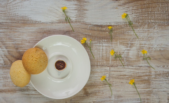 Small cup of coffee with cookies and flowers