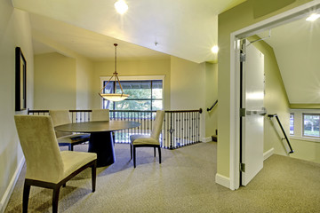 Image of upstairs sitting area in Soft ivory with black table and chairs.