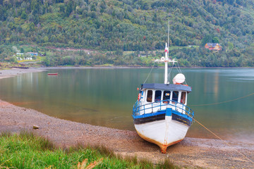 Old boat anchored on the beach of the fjord of Puyuhuapi, Patago