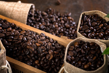 Fototapeta premium Jute bags and wooden containers filled with cofee beans