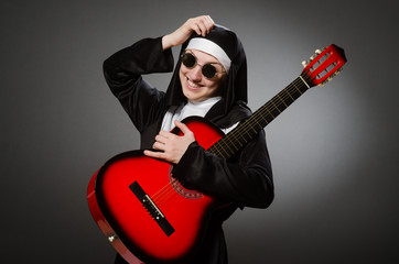 Funny nun with red guitar playing
