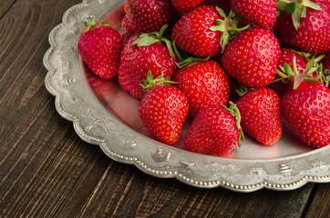 strawberries on vitage plate, wooden background front view
