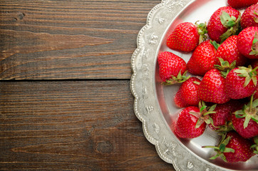 strawberries on vitage plate, wooden background top view