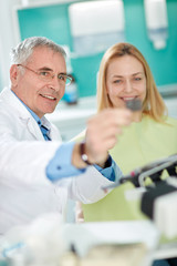 Obraz premium Dentist with female patient look at dental snapshot