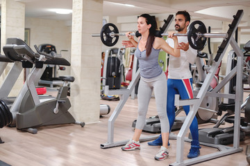 Girl starting squats with trainer