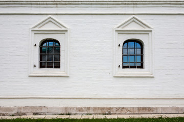 Two windows with bars in brick wall