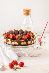 Delicious strawberry cheesecake on white wooden background.