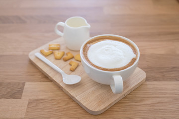 Cup of coffee and biscuit on wooden table