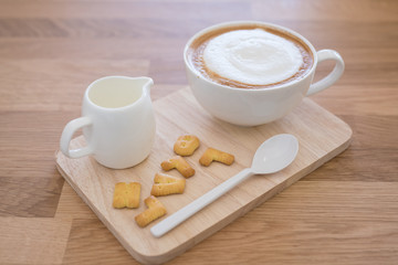 Cup of coffee and biscuit on wooden table
