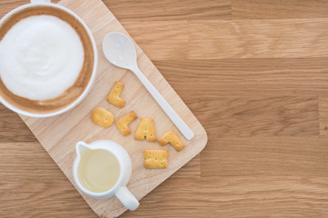 Cup of coffee and biscuit on wooden table