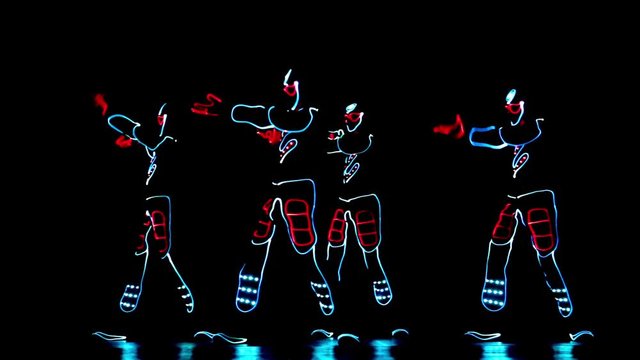 4 people dancing in costumes of LEDs 