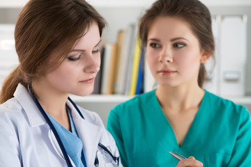 Two sad worried doctors standing at their office