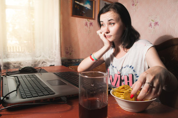woman eating chips for laptop, brunette at home,
