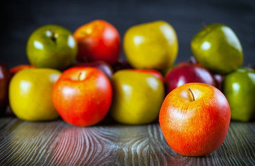 Red apples on wooden table close up front view