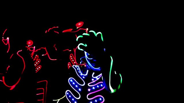 4 people dancing in costumes of LEDs 