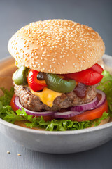 homemade cheese burger with peppers tomato onion