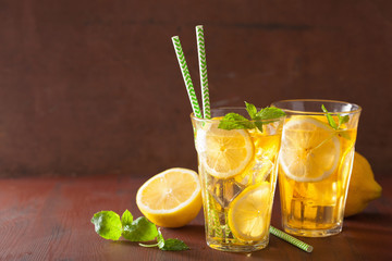 ice tea with lemon and mint on dark rustic background