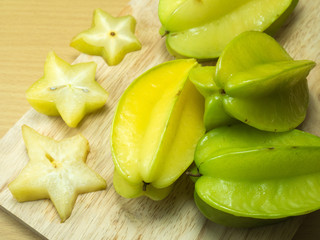 starfruit and starfruit slice on a wood background