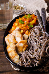 Dark pasta with vegetables and chicken.