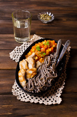 Dark pasta with vegetables and chicken.