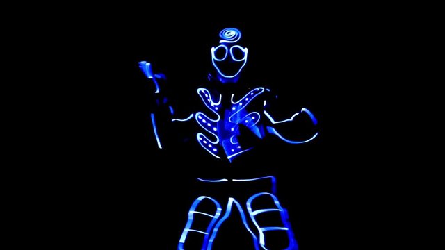 4 people dancing in costumes of LEDs 