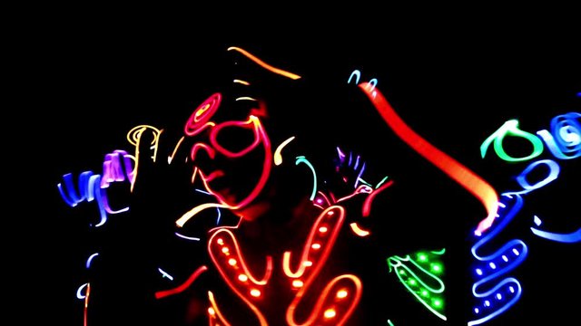 4 people dancing in costumes of LEDs 